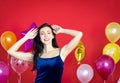 A beautiful woman is smiling behind a balloon on a red background.,happy New Year,Merry Christmas