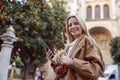 Portrait of lady in leather coat standing outsde and showing thumbs up Royalty Free Stock Photo