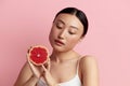 Beautiful Woman Smiling with Grapefruit. Positive Woman Radiant Skin Portrait Royalty Free Stock Photo