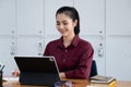 A beautiful woman smiling happily uses a sales profit calculator on the screen of a tablet after increase in sales