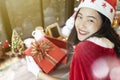 Beautiful woman smiling with her gift box opened and Merry Christmas accessories decorated in room Royalty Free Stock Photo