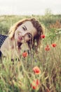 Beautiful woman is smiling and posing in poppy flowers field Royalty Free Stock Photo