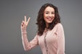 Beautiful woman smiling and showing victory sign