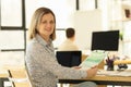 A beautiful woman smiling sits in the office, close-up