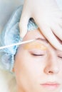 Beautiful woman in spa salon receiving epilation or correction eyebrow Royalty Free Stock Photo