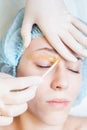 Beautiful woman in spa salon receiving epilation or correction eyebrow Royalty Free Stock Photo