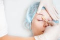 Beautiful woman in spa salon receiving epilation or correction eyebrow Royalty Free Stock Photo