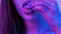 Beautiful Woman with Sparkles on her Face and tongue in ultraviolet light