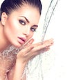 Beautiful woman with splashes of water in her hands Royalty Free Stock Photo