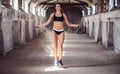 Beautiful woman in sportswear doing exercise with skipping rope in the abandoned industrial building Royalty Free Stock Photo