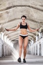 Beautiful woman in sportswear doing exercise with skipping rope in the abandoned industrial building Royalty Free Stock Photo