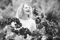 Beautiful woman with spring blooming rose flowers. Young smiling girl enjoys pink rose flowers. Summer time. Happy woman Royalty Free Stock Photo