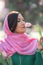 Beautiful woman with spring tulips flowers bouquet at city street. Happy portrait of girl smiling with pink tulip Royalty Free Stock Photo