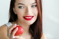 Beautiful woman with stage makeup in a white T-shirt closeup holds fresh fruits in her hands