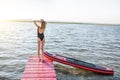 Woman with paddleboard on the pier outdoors Royalty Free Stock Photo