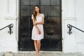 Beautiful woman standing at the black door of the castle, Gothic church . girl in a pink dress, posing close up, resting Royalty Free Stock Photo