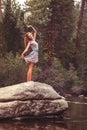 Beautiful woman standing on rock stretching