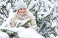 Beautiful woman standing among snowy trees in winter forest and enjoying first snow. Woman in winter woods. Royalty Free Stock Photo