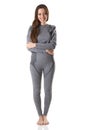 Beautiful woman staying hugging herself with her arms in gray sports thermal underwear.