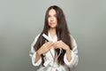 Beautiful woman straighten her hair with straightener on white background. Haircare concept