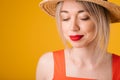 Beautiful woman in straw hat. Closed eyes. Yellow summer mood background. pensive dreamy face