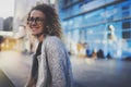 Beautiful woman in stylish clothing wearing eye glasses outside in the european night city. Bokeh and flares effect on