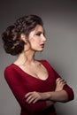 Beautiful woman with stylish haircut and big earrings looking down over shoulder, touching neck by hand. Brunette girl Royalty Free Stock Photo