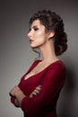 Beautiful woman with stylish haircut and big earrings looking down over shoulder, touching neck by hand. Brunette girl Royalty Free Stock Photo