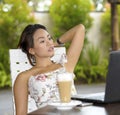 Beautiful woman in Summer dress outdoors at nice coffee shop having breakfast networking or working with laptop computer Royalty Free Stock Photo