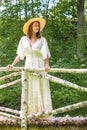 Beautiful woman in summer hat and white dress in an old park Royalty Free Stock Photo