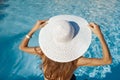 Beautiful woman sunbathing on a beach at tropical travel resort, enjoying summer holidays. Girl holding a hat with her Royalty Free Stock Photo