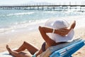 Beautiful woman sunbathing on a beach at tropical travel resort, enjoying summer holidays. Girl lying on sun lounger Royalty Free Stock Photo