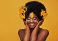 Beautiful woman, sunflowers in hair and make up on face in studio for cosmetics, afro care and empowerment. Happy, black Royalty Free Stock Photo