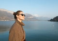 Beautiful woman in sunglasses on a background of lake and mountains