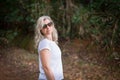 Beautiful woman in sunglasses, in the forest, looking at the camera Royalty Free Stock Photo