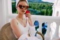 beautiful woman in sunglasses sits on the balcony and uses the phone Mountain View Royalty Free Stock Photo