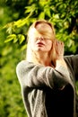Beautiful woman in the sunny forest, covered her face with hair, fooled.