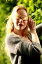 Beautiful woman in the sunny forest, covered her face with hair, fooled.