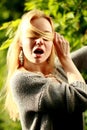 Beautiful woman in the sunny forest, covered her face with hair, fooled.