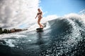 Beautiful woman in swimsuit stands on surfboard and rides down the wave Royalty Free Stock Photo