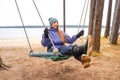 Beautiful woman on Swing, river background. Autumn