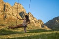 Beautiful woman swinging on a swing in nature with Table Mountain in the background.