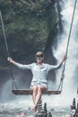 Beautiful woman swings near waterfall in the jungle of Bali island, Indonesia. Royalty Free Stock Photo