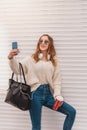 Beautiful woman takes selfie while leaning on a wall Royalty Free Stock Photo