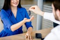 Beautiful woman taking car key from dealer Royalty Free Stock Photo