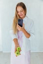 Beautiful woman taking pictures of apples in hand on her phone Royalty Free Stock Photo