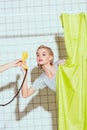 beautiful woman taking yellow retro telephone handset in shower