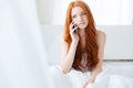 Beautiful woman talking on cell phone in bed Royalty Free Stock Photo