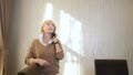 Beautiful woman talking on a cell phone, standing in the office by the window Royalty Free Stock Photo