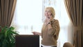 Beautiful woman talking on a cell phone, standing in the office by the window Royalty Free Stock Photo